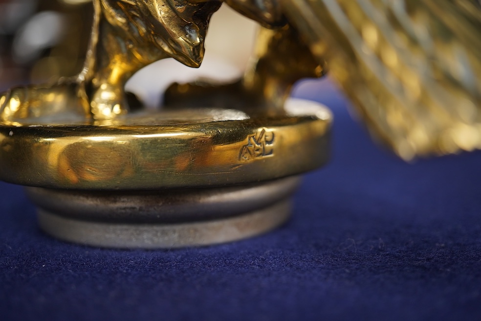 Two brass car mascots in the form of eagles, one mounted on a threaded radiator cap, the other mounted on a wooden base, the larger with a wingspan of 31cm. Condition - fair, one eagle with bent wing.